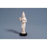 An Indian carved ivory figure of a goddess holding flowers in her hands, ca. 1900