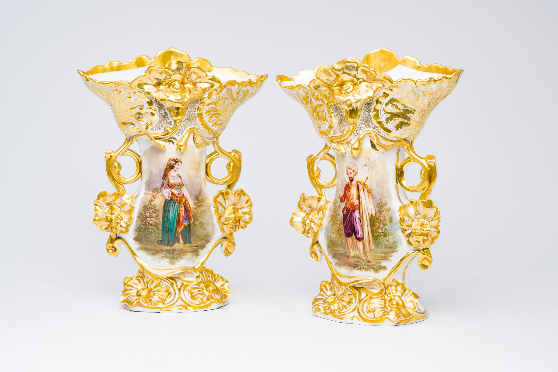 A pair of French gilt and polychrome old Paris porcelain vases with an Indian couple and floral reli