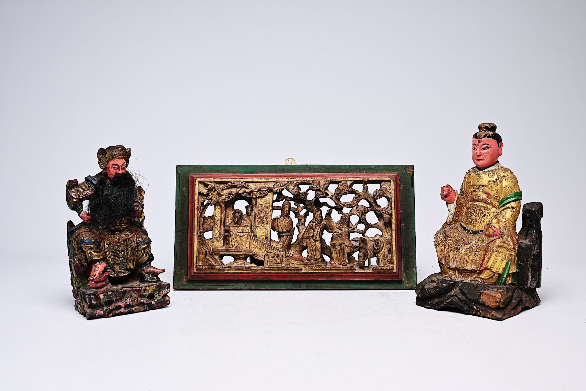 Two Chinese polychromed wood votive figures and a gilt panel, 19th C.