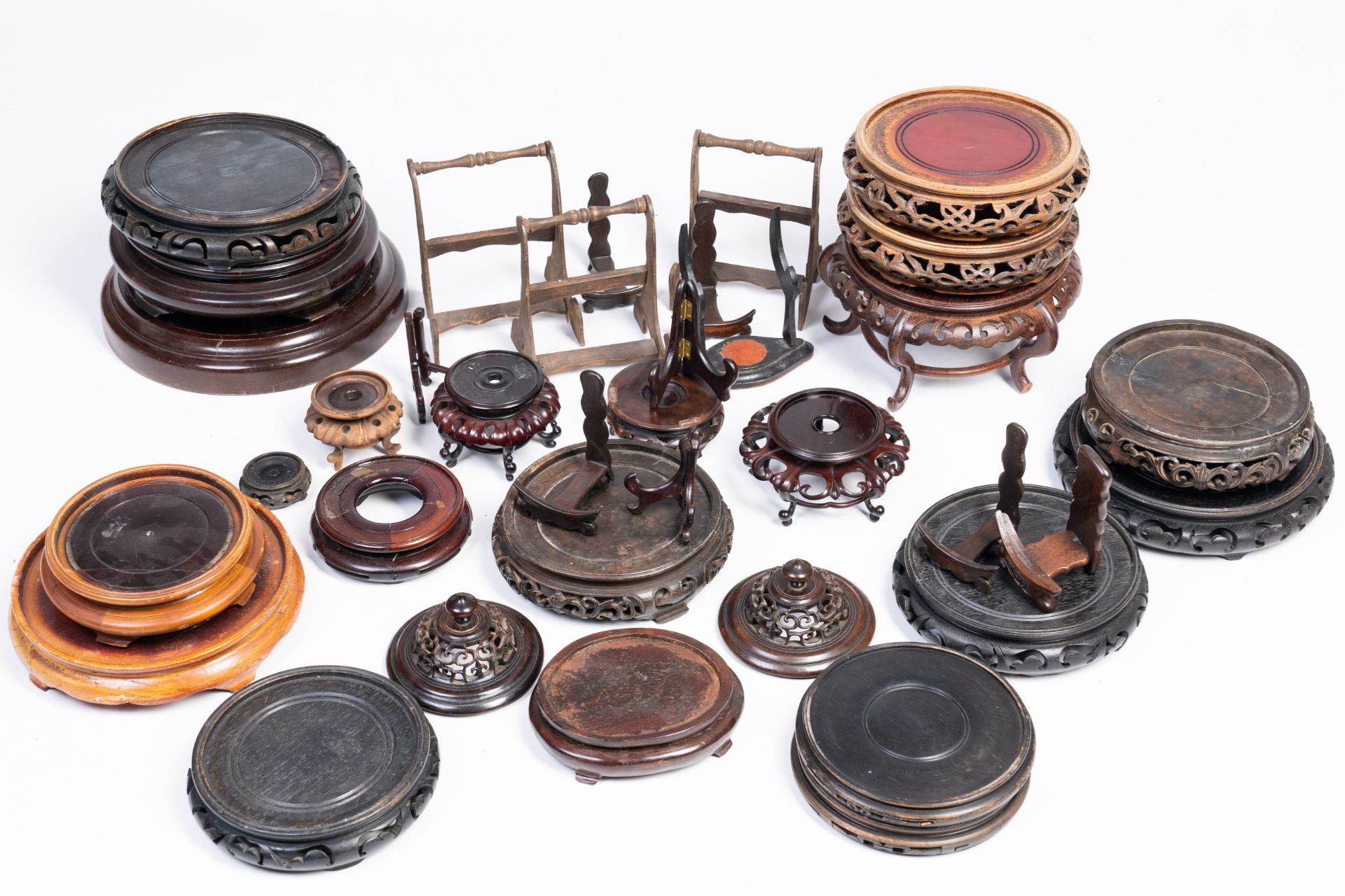 A varied collection of Chinese carved wood stands and covers, 19th/20th C.