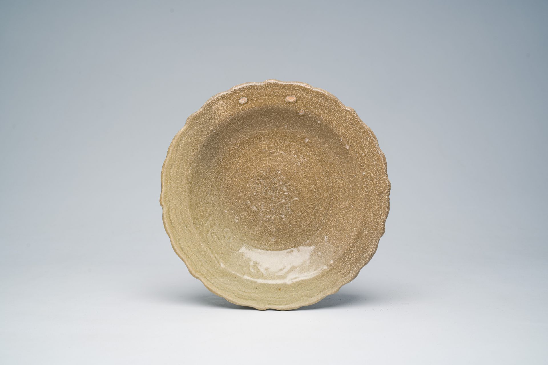 A Chinese Longquan celadon lotus-shaped plate with incised floral design, Ming