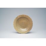 A Chinese Longquan celadon lotus-shaped plate with incised floral design, Ming