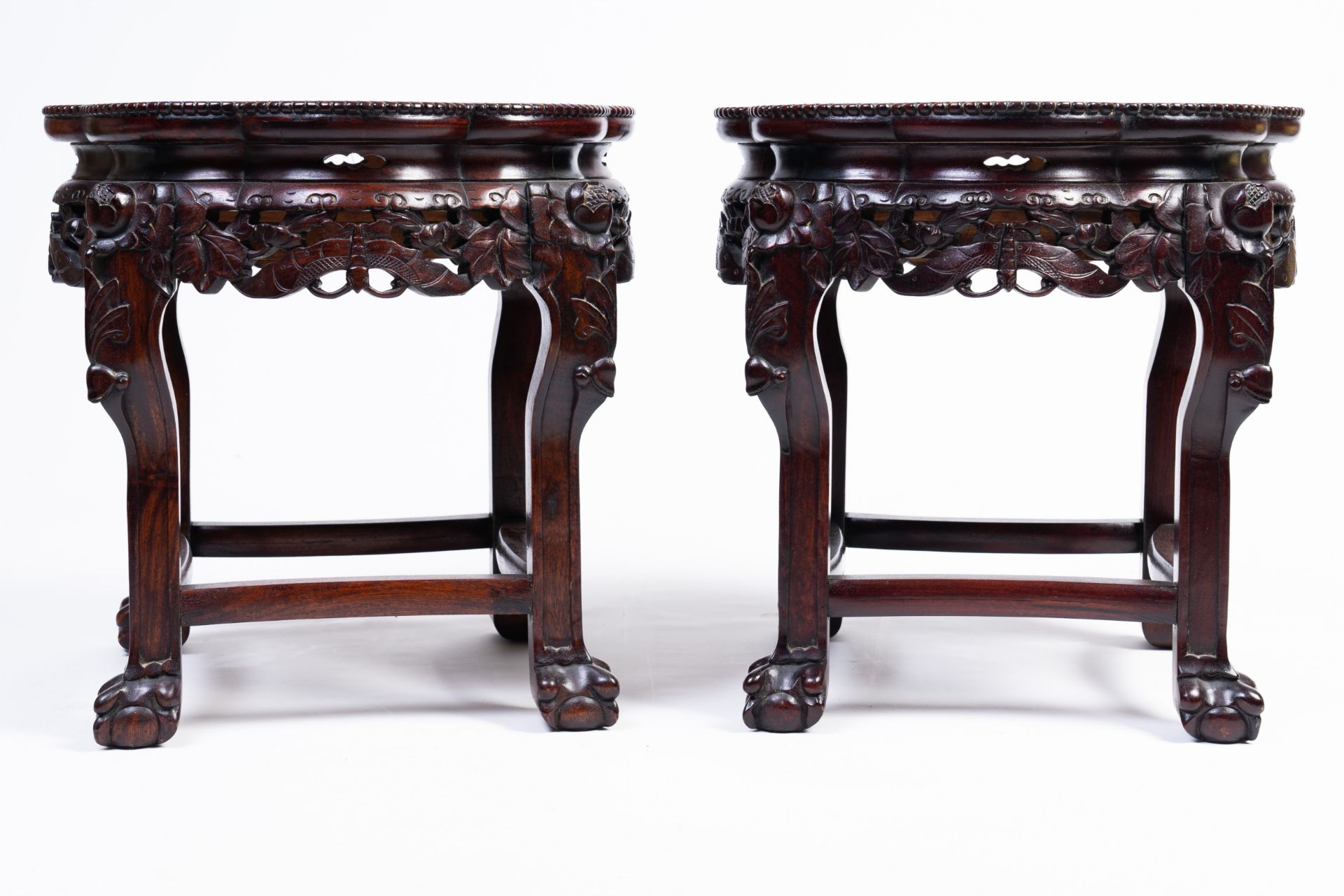 A pair of Chinese reticulated hardwood stands with marble tops, 20th C.