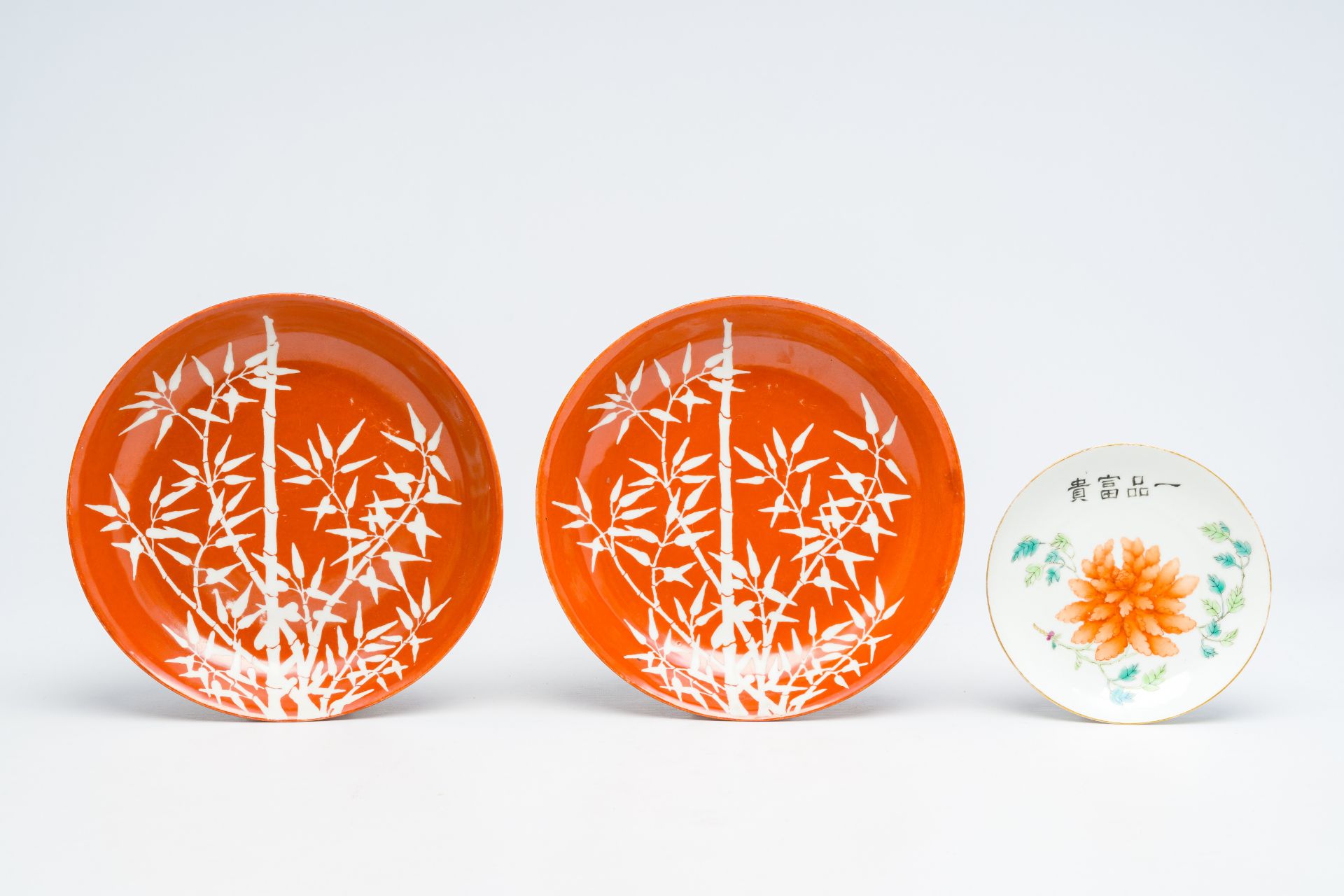 A pair of Chinese coral red ground 'bamboo' plates and a famille rose 'peony' saucer, 19th/20th C. - Image 2 of 3