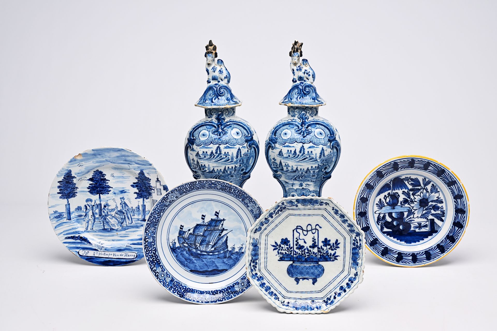 A pair of Dutch Delft blue and white vases and covers with landscapes and four various plates, 18th/
