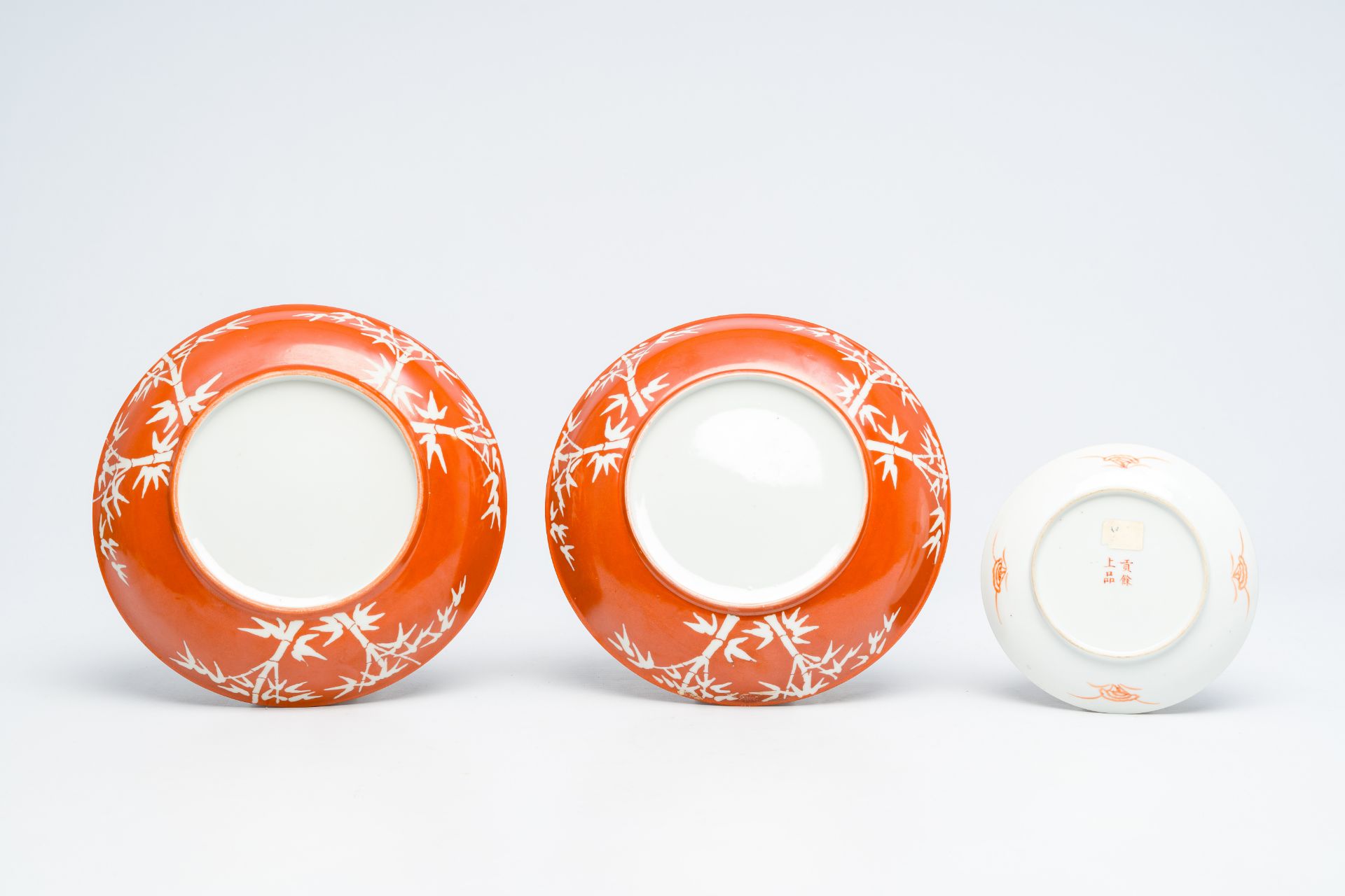 A pair of Chinese coral red ground 'bamboo' plates and a famille rose 'peony' saucer, 19th/20th C. - Image 3 of 3