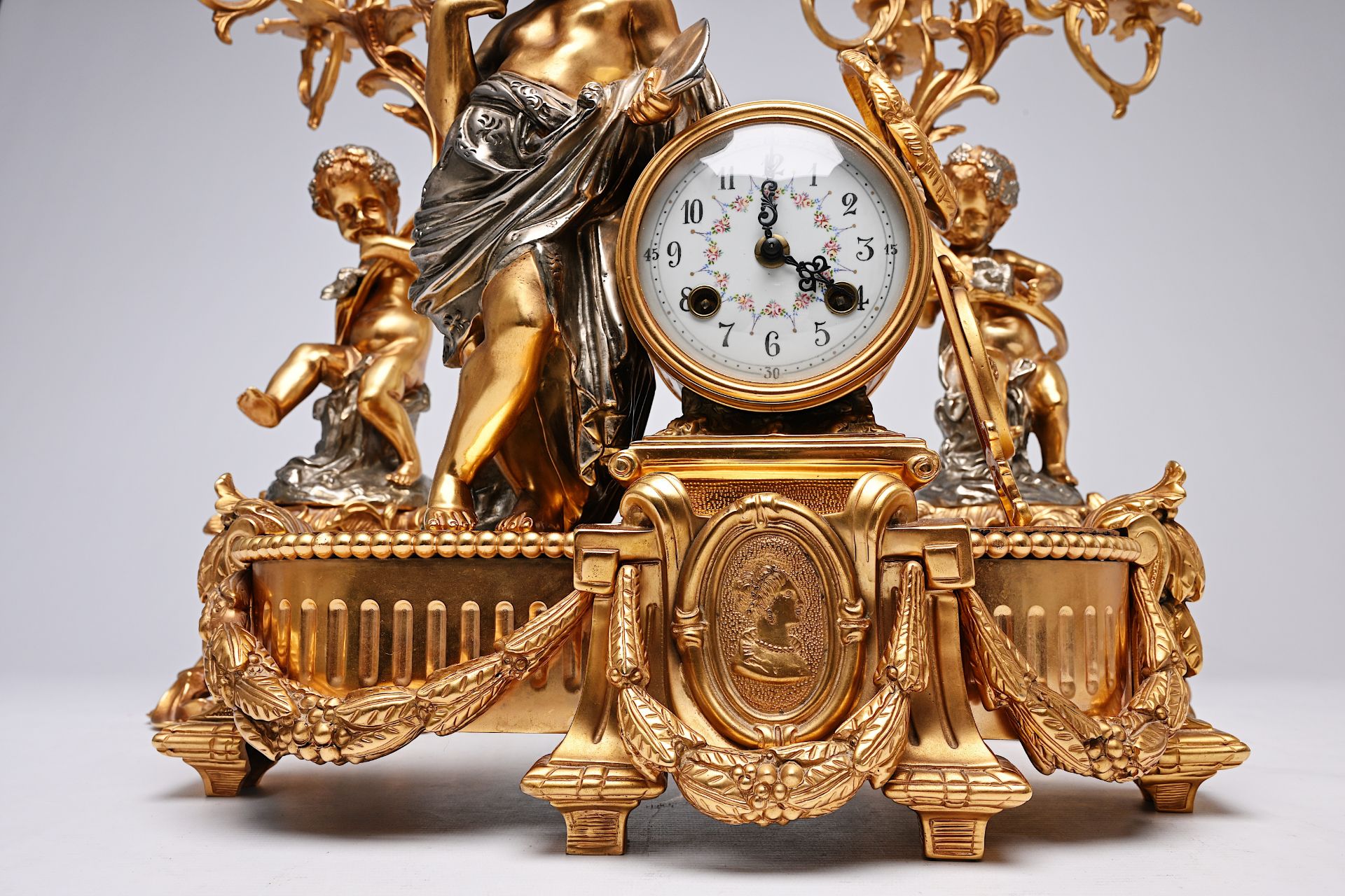 A French three-piece partly gilt metal clock garniture with putti, 20th C. - Image 9 of 11