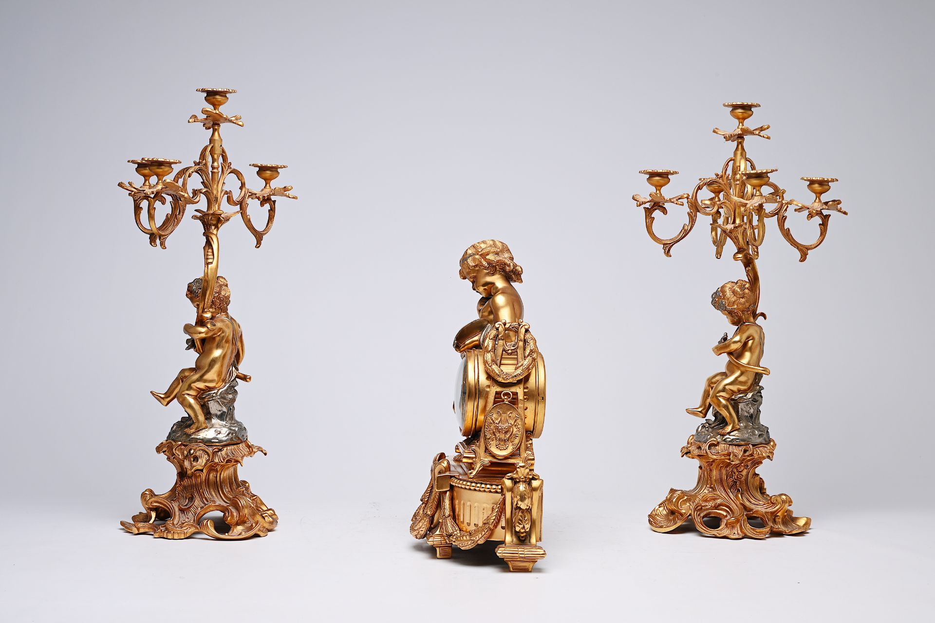 A French three-piece partly gilt metal clock garniture with putti, 20th C. - Image 5 of 11