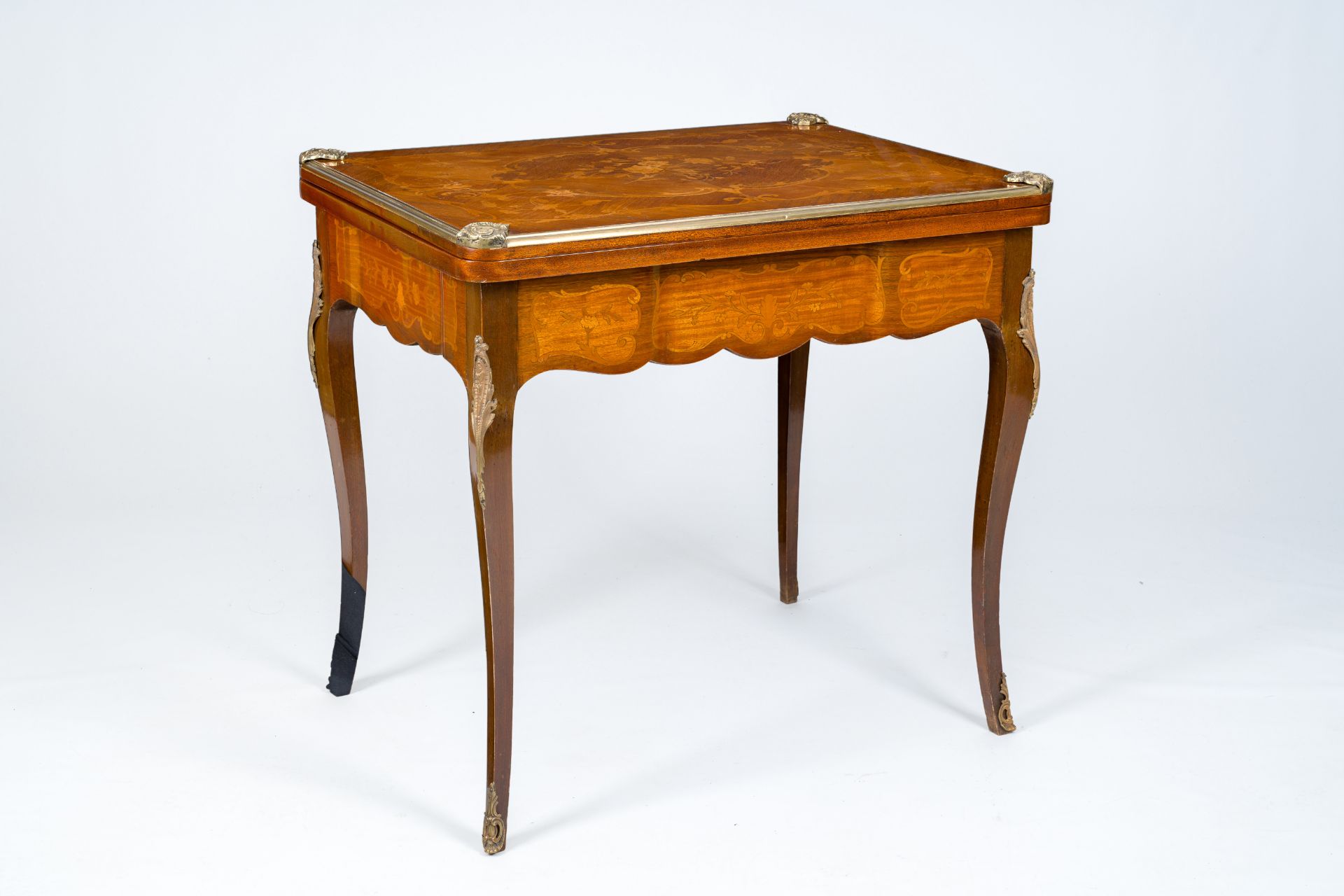 A French bronze mounted wood game table with marquetry top, 19th/20th C.