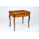 A French bronze mounted wood game table with marquetry top, 19th/20th C.