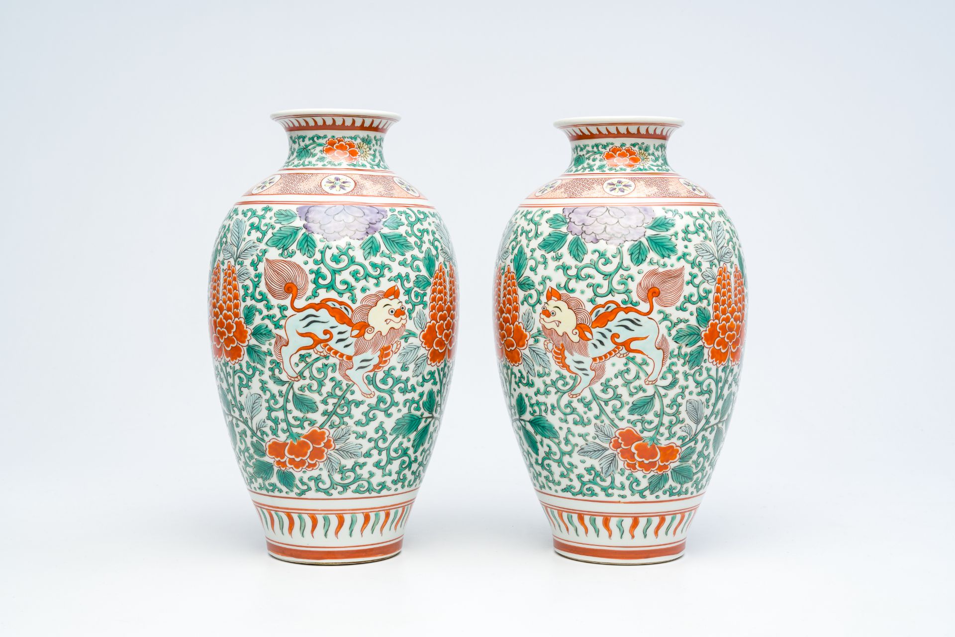 A pair of Japanese wucai style 'peony and Buddhist lions' vases, Meiji, ca. 1900