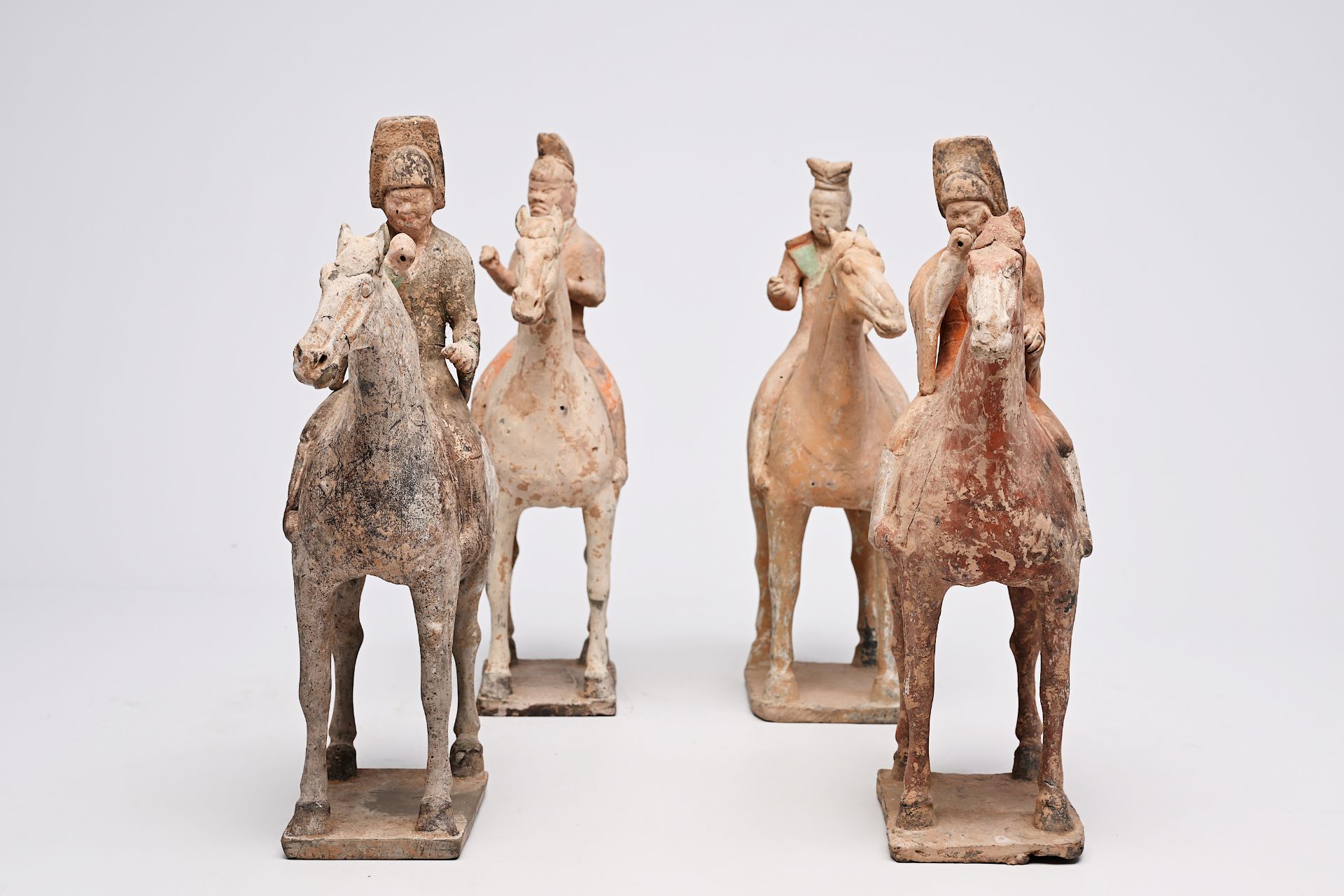 Four Chinese polychrome painted pottery equestrian figures, Tang