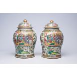 A pair of Chinese Canton famille rose vases and covers with palace scenes and birds and butterflies