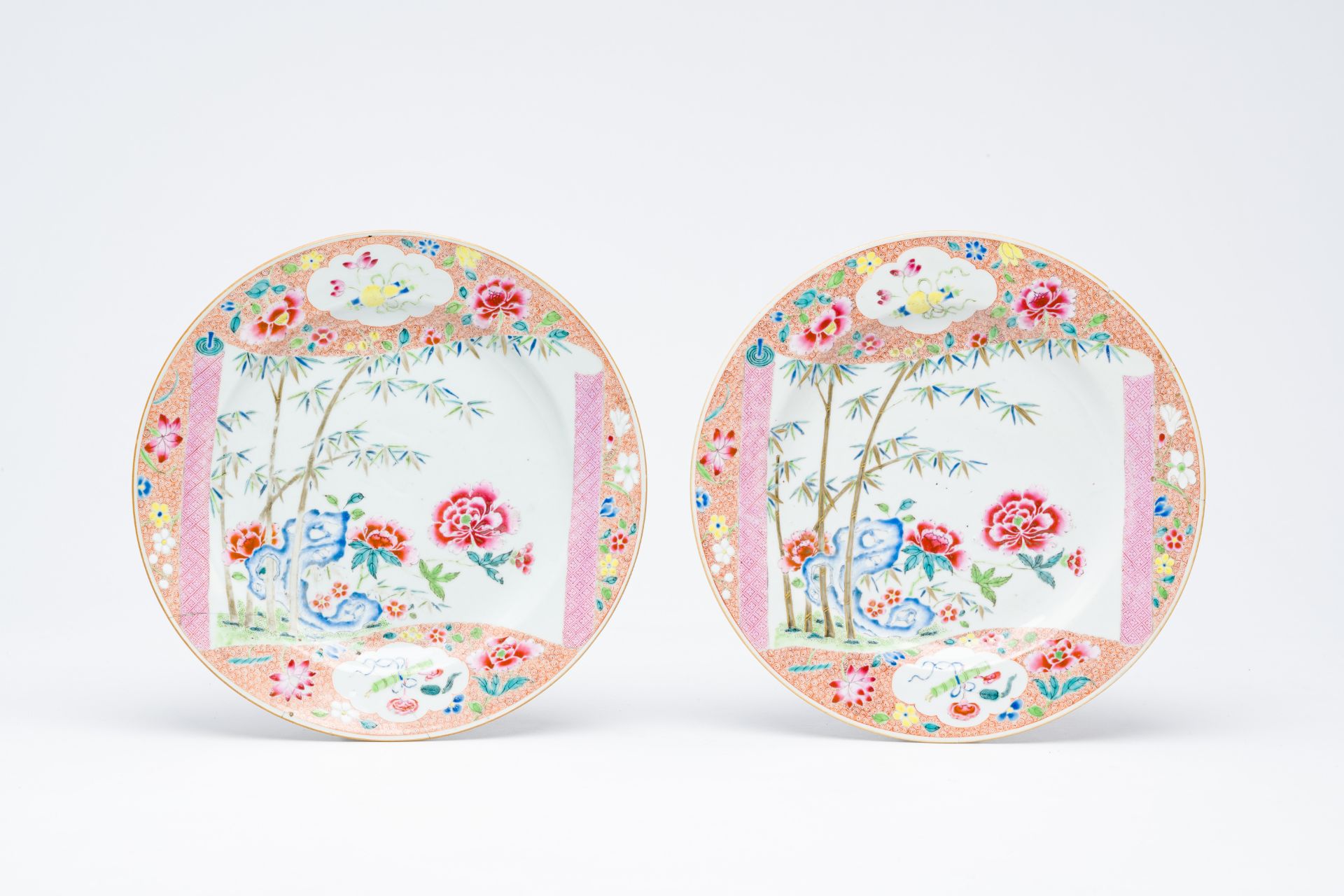 A pair of Chinese famille rose plates with a scroll with floral design, Yongzheng