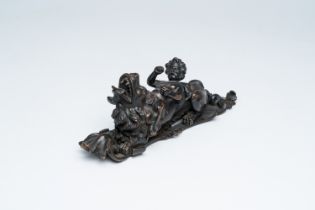 A Flemish patinated bronze door knocker with a jolly putto on a lion, presumably Antwerp, early 18th
