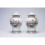 A pair of Chinese famille rose vases and covers with ladies on a terrace, Qianlong mark, Republic, 2