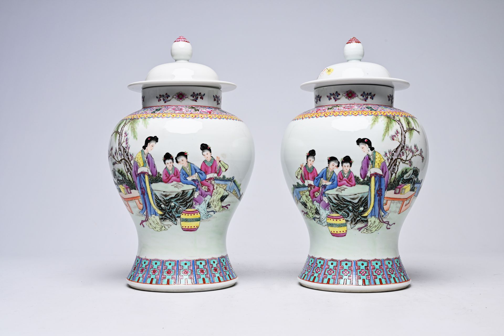 A pair of Chinese famille rose vases and covers with ladies on a terrace, Qianlong mark, Republic, 2