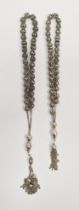 Two strings of continental silver-coloured metal worry beads, pierced basket-pattern with tassel