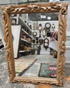 A rectangular mirror within a carved stripped wood frame, 70 cm x 51 cm