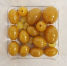 Quantity unstrung yellow-coloured amber-type oval beads