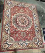 Persian-style Eastern wool rug, the red field with single large flowerhead arabesque, allover