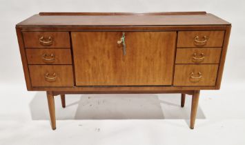 Mid-century teak sideboard with central fall-front storage cupboard flanked by three short drawers