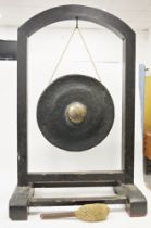 South East Asian bronze temple gong on ebonised stand, the circular gong with central boss,