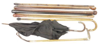 Collection of walking canes, sticks and other items including an early 20th century silver and