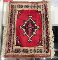 Bokhara rug with single lozenge on a cherry red ground, 24cm x 33cm