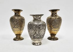 Pair of Middle Eastern white metal gilt vases, each with embossed foliate motifs, 16cm high and a