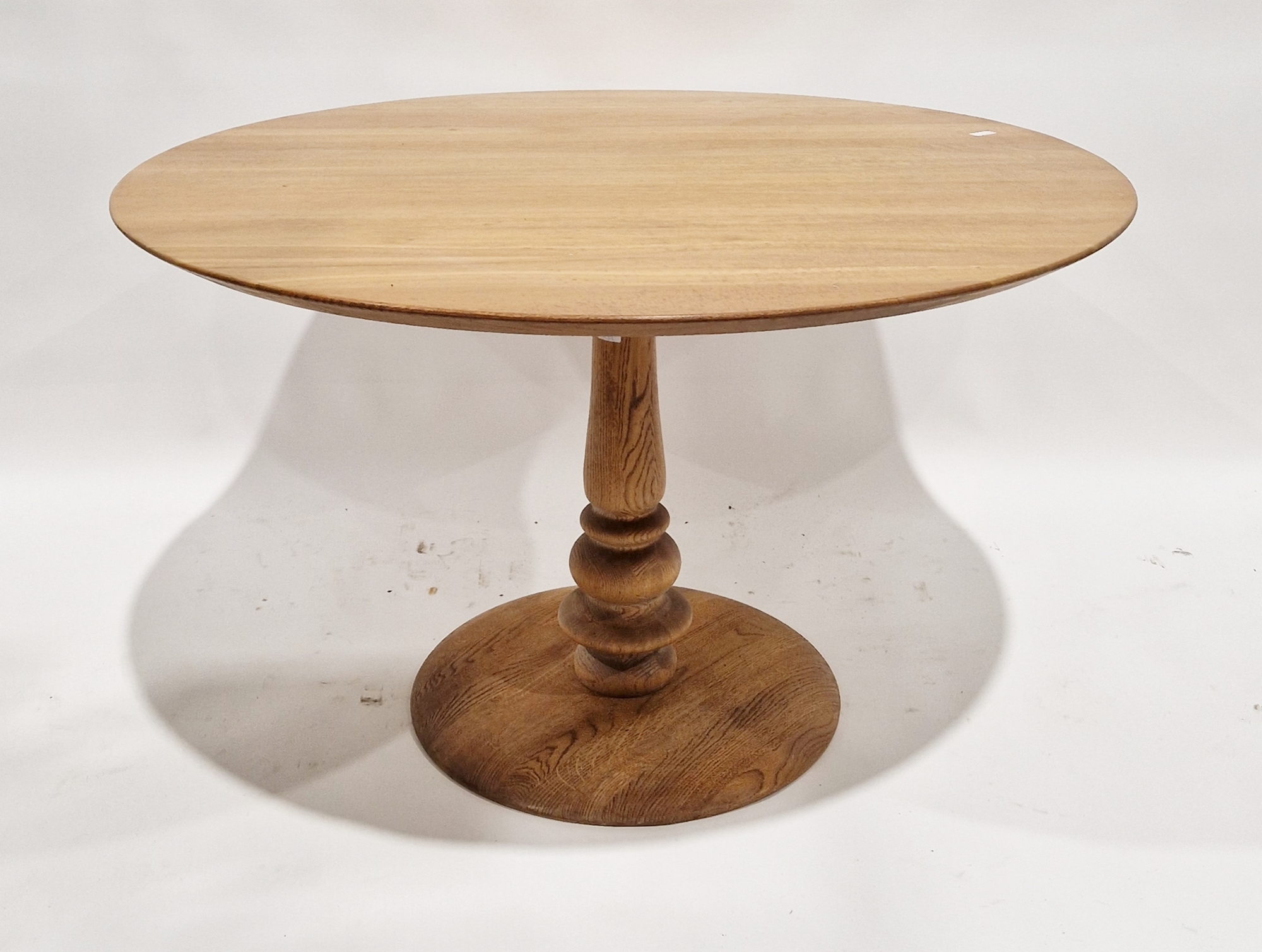 Light oak dining table of circular form, with turned column and circular foot, 73cm high x 121cm