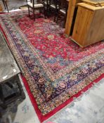 Large carpet of Persian design, having central floral arabesque and surround of scrolling foliage