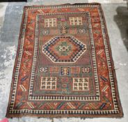 Caucasian rug with central hooked lozenge on green ground flanked by hooked squares with floral