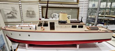 Wooden kit model motorised cabin cruiser boat with red and white painted hull and brass propeller,
