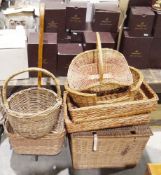 Selection of wicker baskets to include a picnic hamper, a shopping basket trolley, bread baskets,