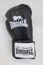 Cased black Lonsdale boxing glove signed by Frank Bruno, a framed black football boot signed by