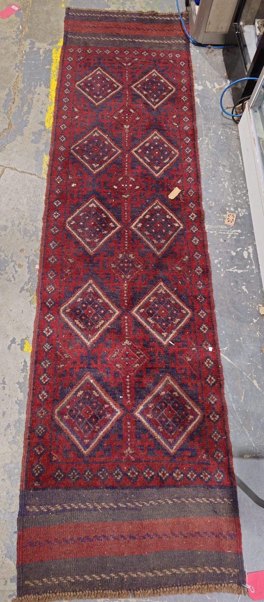 Meshwani runner having two rows of five lozenge-shaped medallions to the red ground, stylised