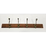 Set of four Art Nouveau brass coat hooks of entwined tendril form, later mounted on a teak plank,