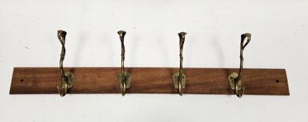 Set of four Art Nouveau brass coat hooks of entwined tendril form, later mounted on a teak plank,