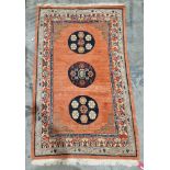 Oriental-style red ground rug, the central panel with three circular floral medallions and