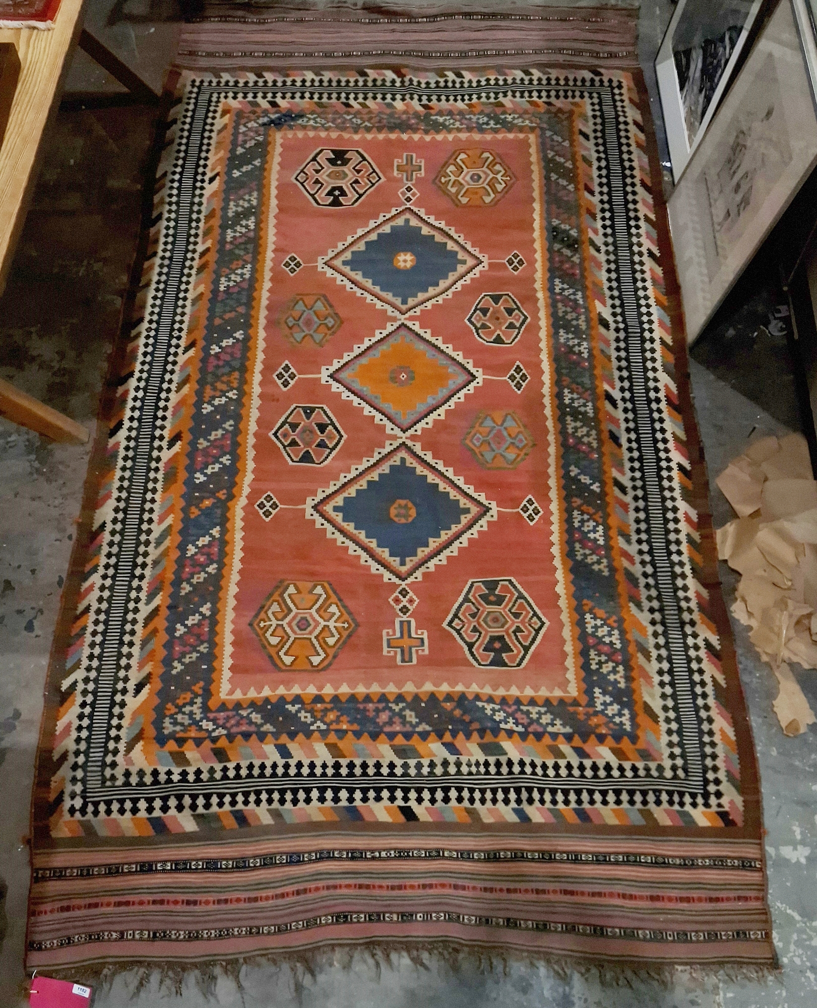 19th century red ground kilim with three central lozenges, eight elephant's foot guls and multiple