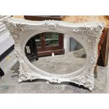 Large white painted rectangular wall mirror with high relief moulded floral decorated frame,