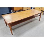 Mid-century teak coffee table of rectangular form with a newspaper tray, on turned legs, 41cm high x