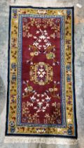 Chinese superwash burgundy ground rug, central floral medallion on stylised floral field, multiple