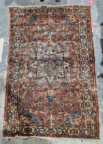 Eastern red ground rug with central floral medallion, stylised floral field, blue spandrals to