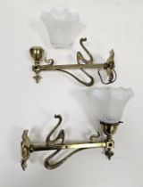 Pair of Art Nouveau brass wall lights with whiplash design decoration, the sconces inscribed '