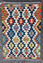 Chobi kilim, woven with a geometric medallion in red, blue and ochre reserved on a cream ground