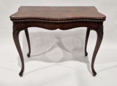 George III mahogany foldover card table of French Hepplewhite style, the shaped top with carved
