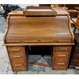 Early 20th century oak roll-top desk, the top with tambour cover and fitted interior, over one