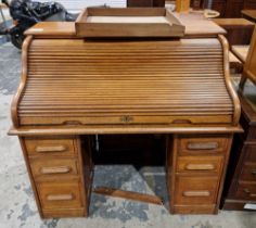 Early 20th century oak roll-top desk, the top with tambour cover and fitted interior, over one